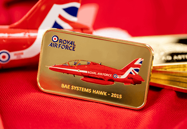 Front of the Red Arrows Gold-Plated Ingot showing an illustration of the 2015 BAE Systems Hawk, displayed in front of a Red Arrows plane model