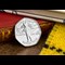 The Rupert Bear Brilliant Uncirculated 50p in display card leaning on a red and gold book spine on a wooden surface