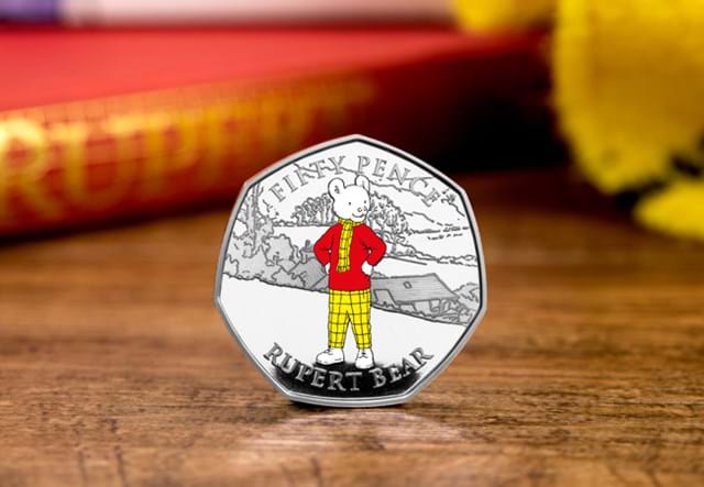 The Rupert Bear Silver Proof 50p Coin stood on wooden surface