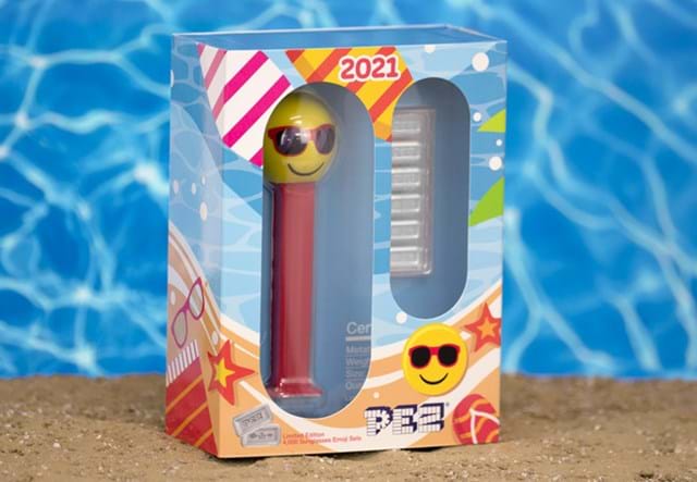 Pez Dispenser in Box on Sand with Background of Blue Waves