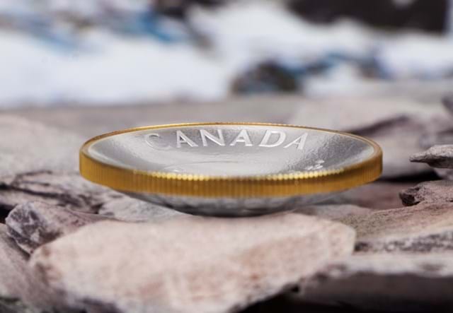 Canada 2021 Klondike Gold Rush Silver Proof Coin from the side on rocks