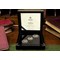 East India Company 2022 Platinum Jubilee Gold Proof 3-Coin Set in the display box on a desk beside books